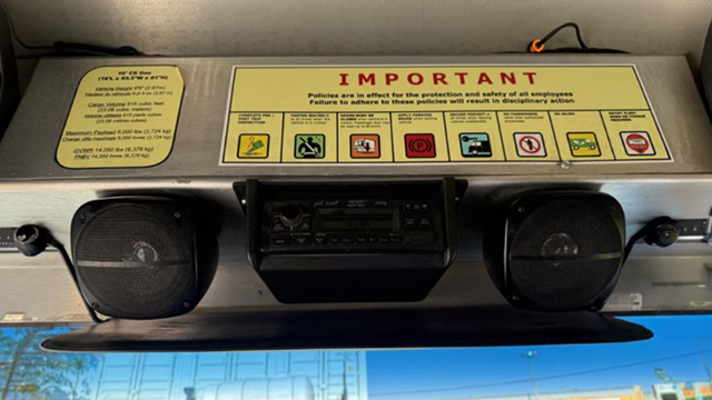 Overhead radio, speakers, and safety notice in the cab